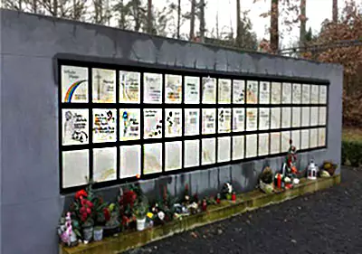 Urnenplatten Eine Reihe von Urnenplatten mit Blumen und Kerzen davor